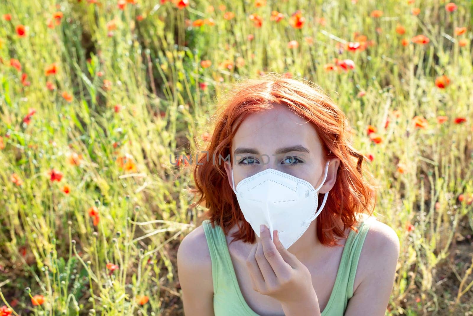 frustrated young girl with protective mask in poppy field