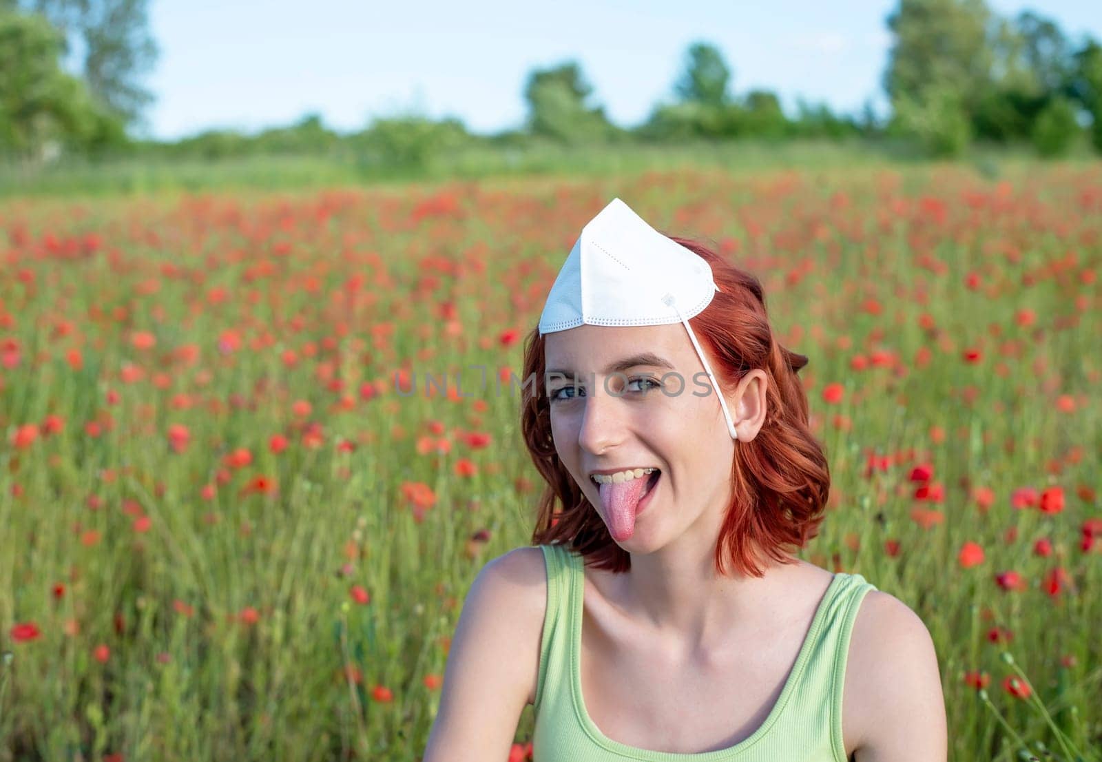 girl with mask on her head sticks her tongue out