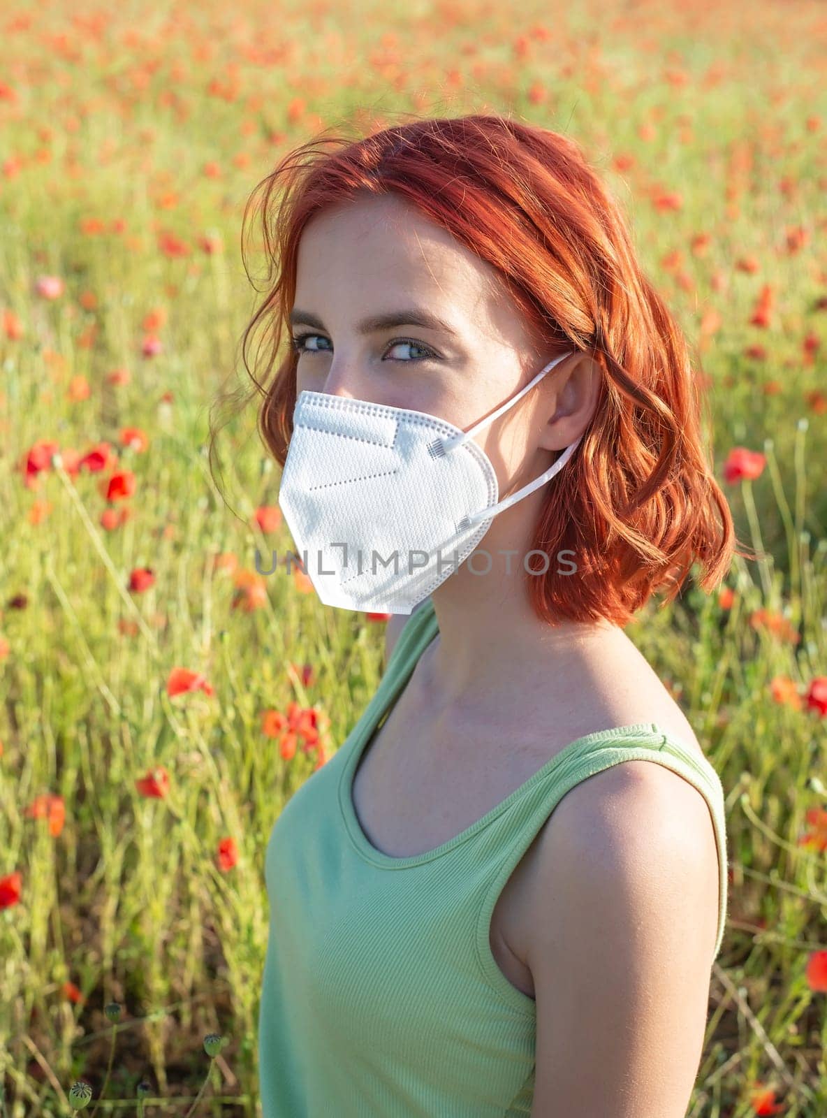 young girl with protective mask in poppy field