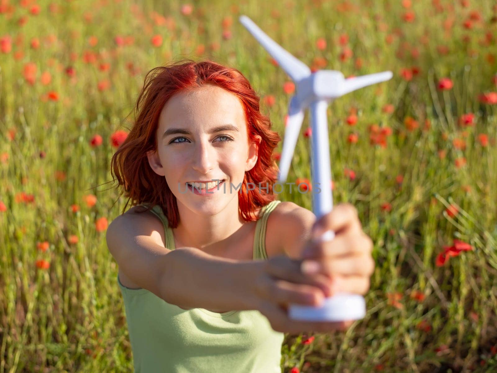 girl with wind turbine in poppy field