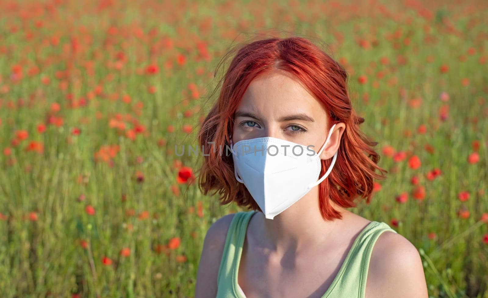 frustrated young girl with protective mask in poppy field