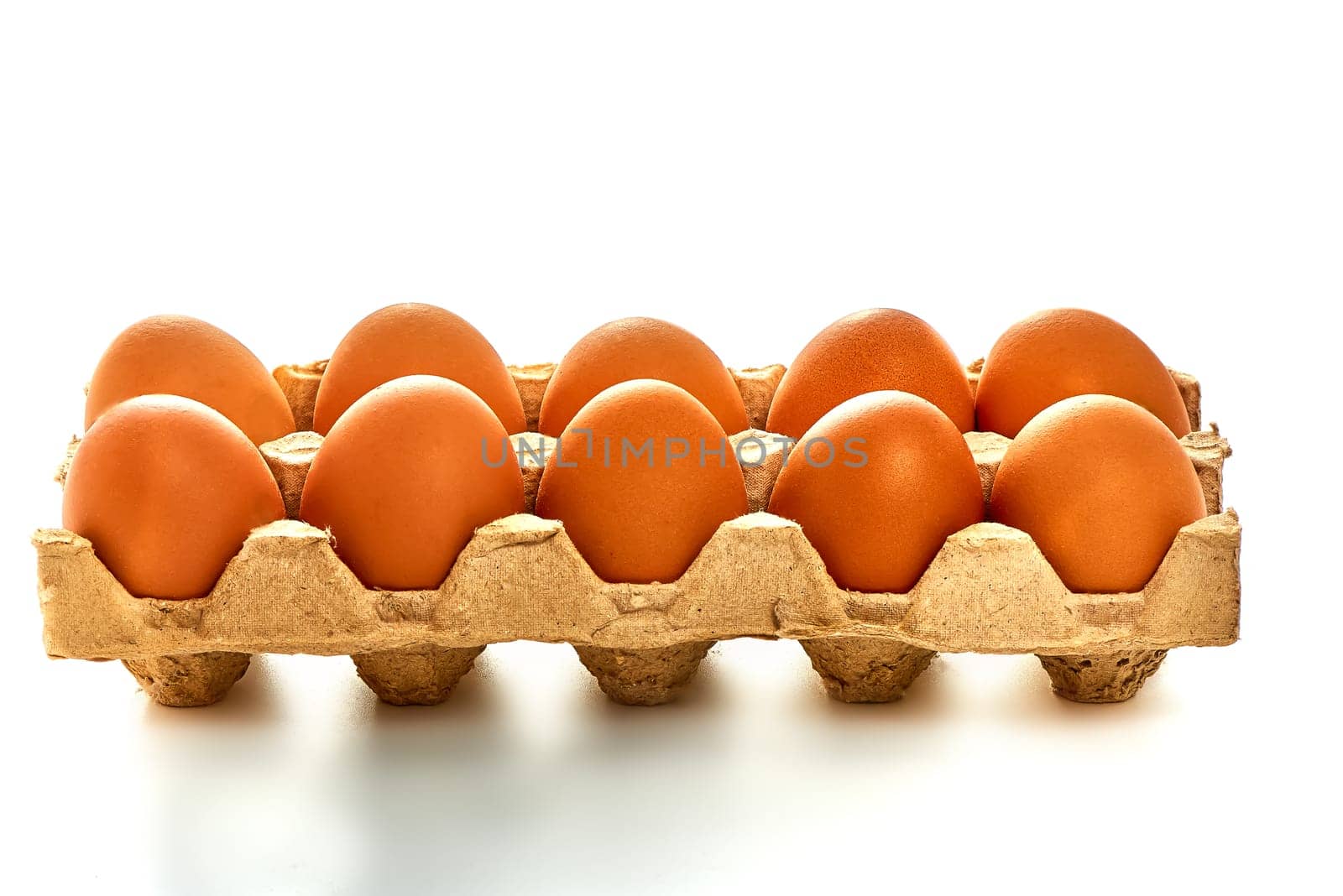 A dozen white eggs on a cardboard stand on a white isolated background. High quality photo