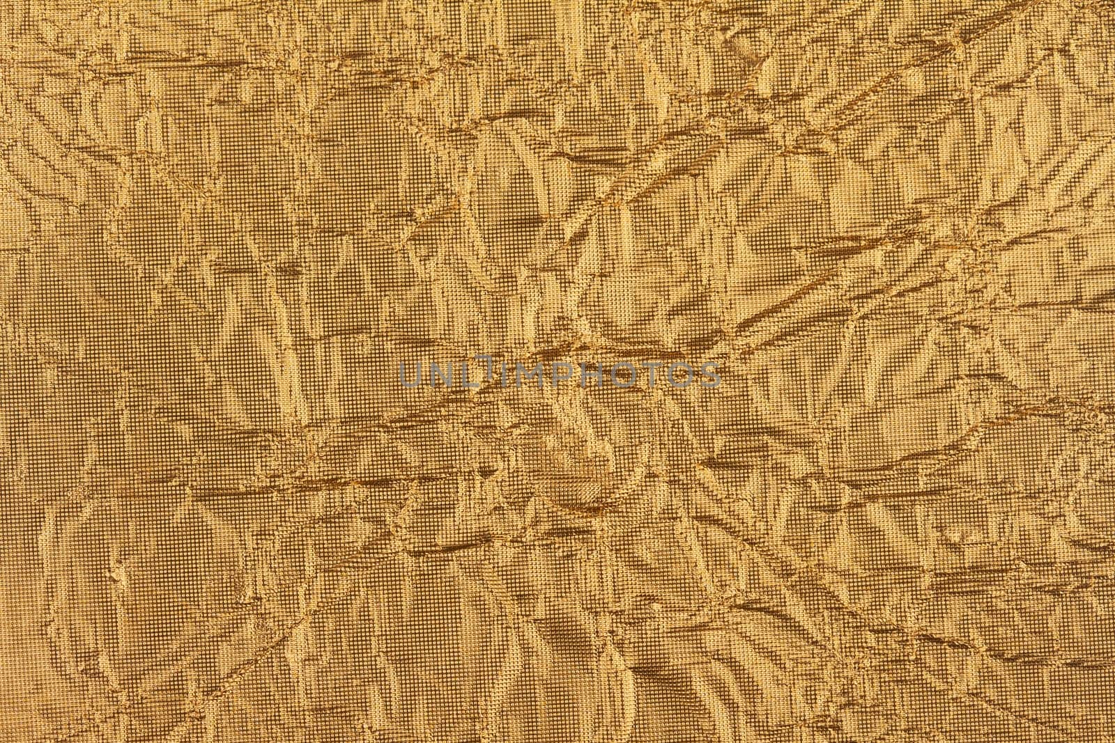 top view detail closeup of textured wrapping paper gold foil leaf with wrinkled surface and embossed decoration