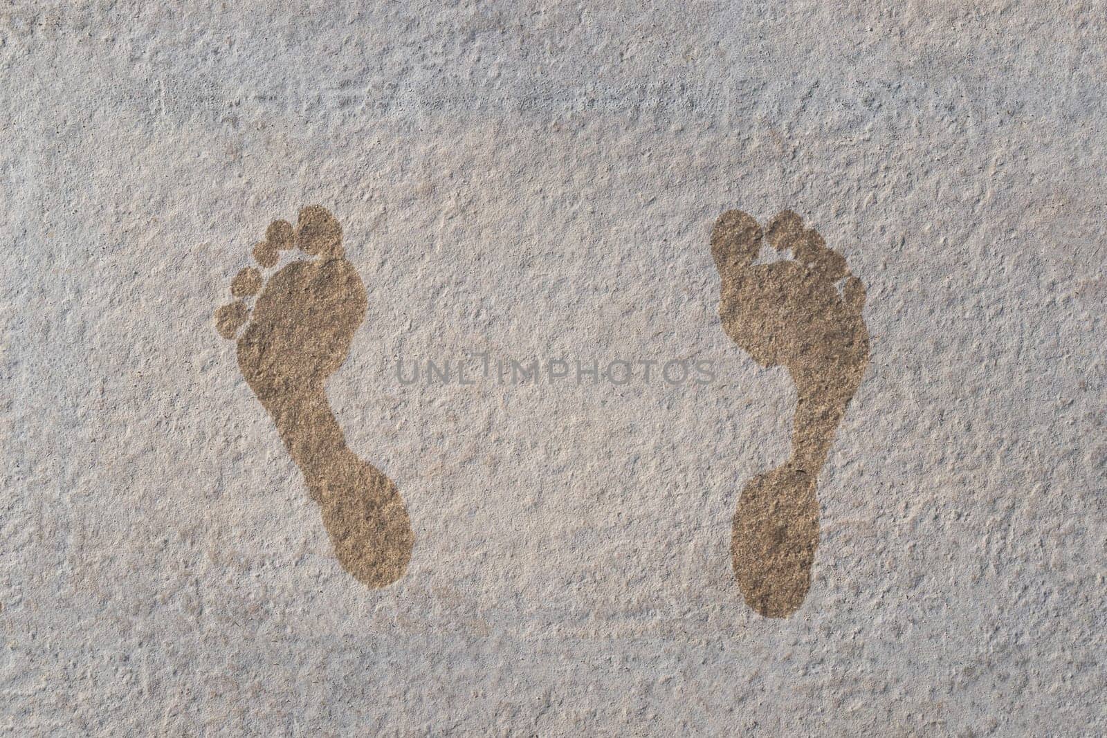 closeup top view of child wet footprints on stone tile