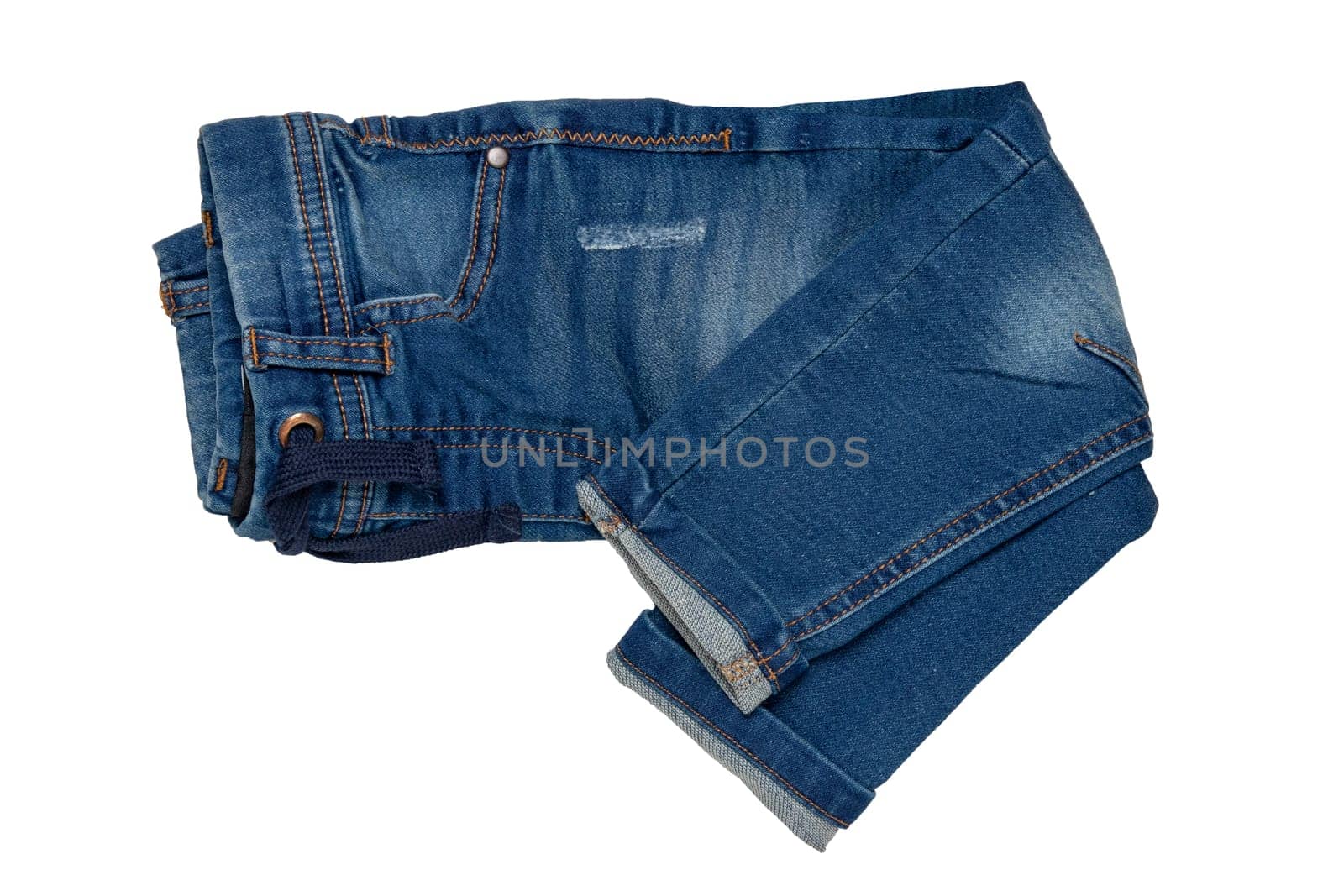 Blue jeans isolated. Closeup of a folded trendy stylish dark blue denim pants or trousers for boys isolated on a white background. Kids summer and autumn fashion. Front view.
