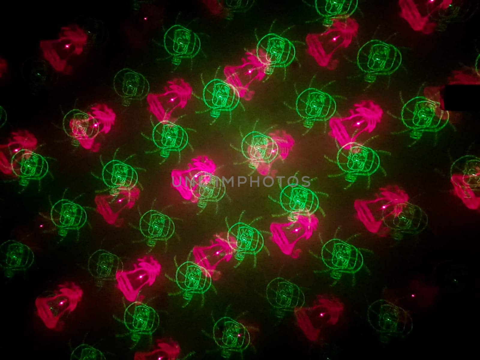 A beautiful shot of laser lights with star and firework shapes on the wall.
