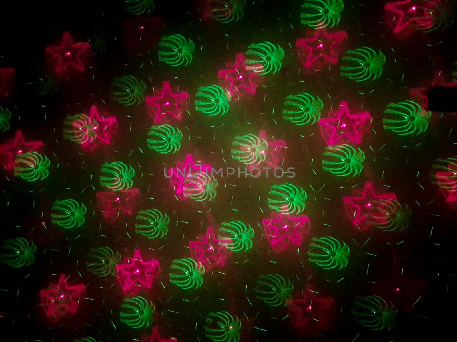 A beautiful shot of laser lights with star and firework shapes on the wall.