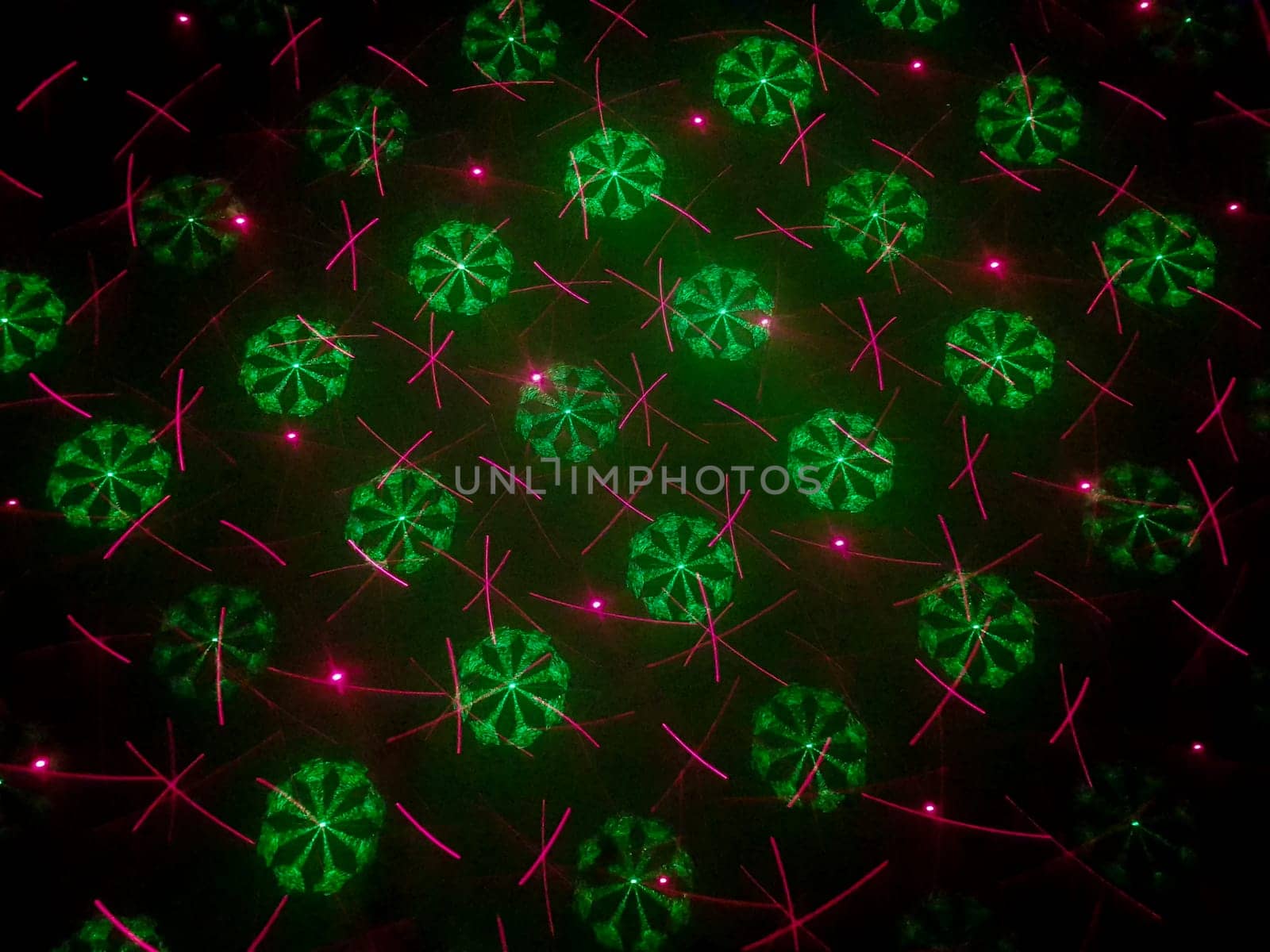 A beautiful shot of laser lights with star and firework shapes on the wall.