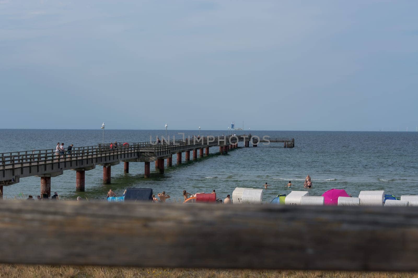Ostseebad Prerow - July 31, 2018:.Fishermen and tourists on the wooden pier of the Prerow seaside resort.