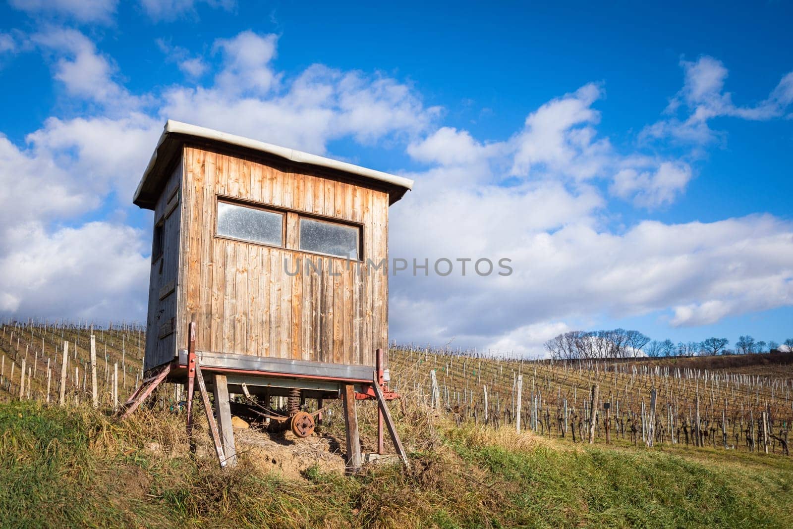 Wooden hunters high seat hide on field with cloudy dramatic sky background
