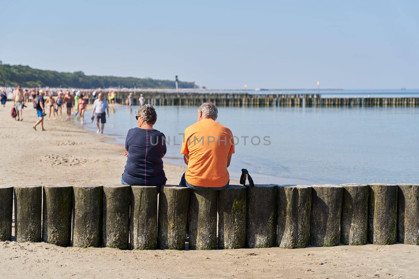 Couple on a breakwater on the beach of Kolobrzeg on the Baltic Sea in Poland