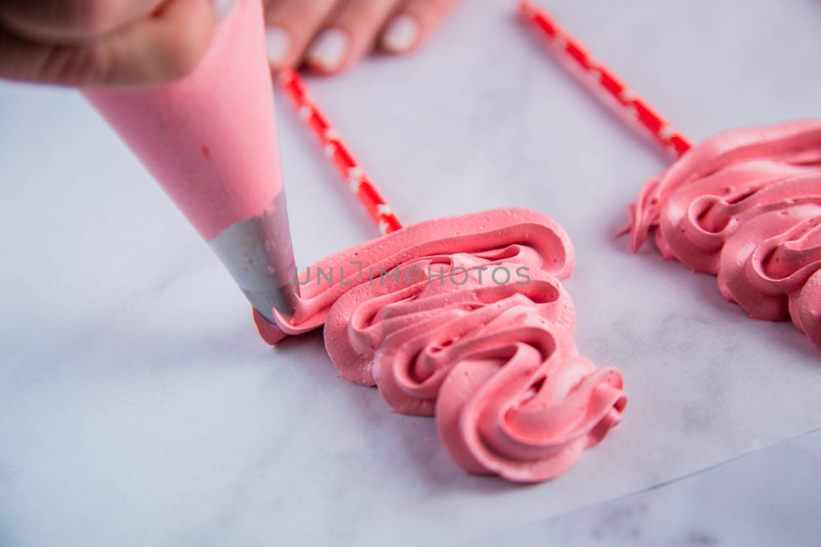 From the pastry bag, a pink bizet is laid out on baking paper with curls in the form of a Christmas tree. High quality photo