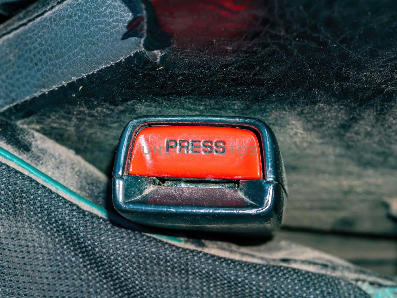 The red button of the car seat belt buckle. Vehicle seat belt buckle. Traffic Laws. Protection of the driver and passengers of the car. Protection in a traffic accident. Blocking during an accident.