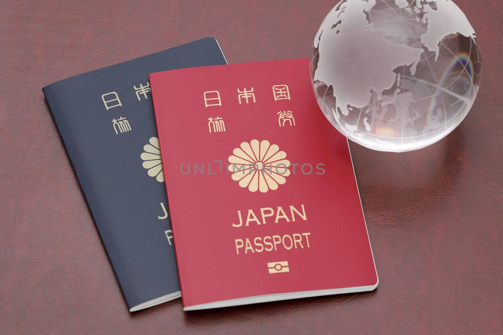 Japanese passport with glass globe on red leather background