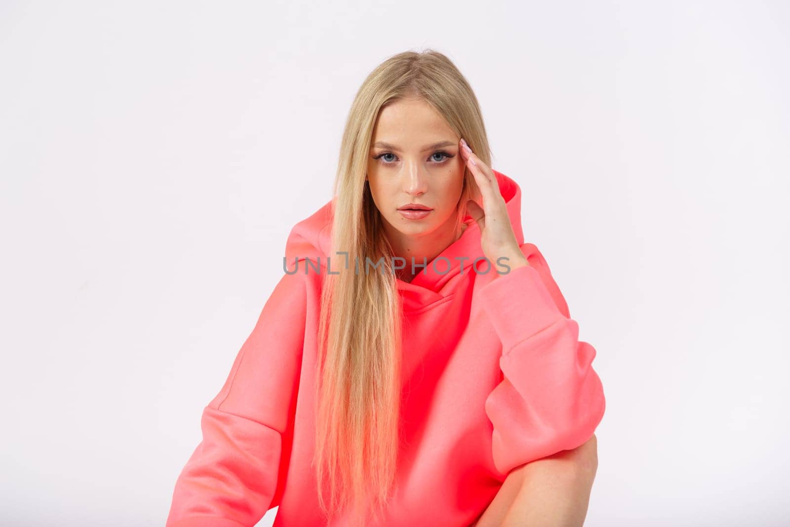 Young pretty woman wearing yellow hoodie and gray cycling shorts on white background. Casual women sport look