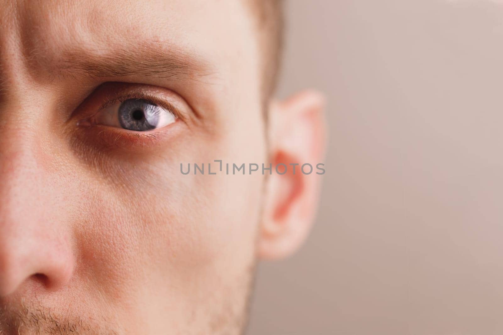 Young worried man with stern look. Sad expression. Close-up portrait half face. Mental health