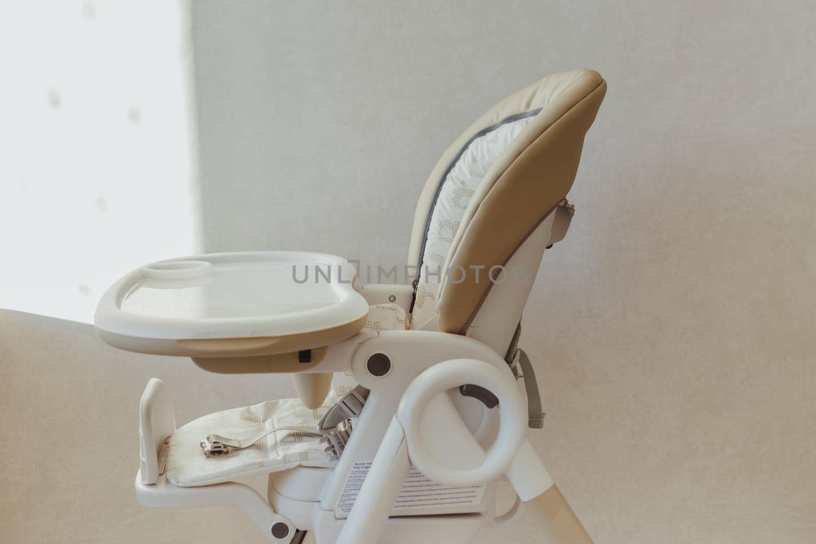 Baby nibbler on high chair in interior.