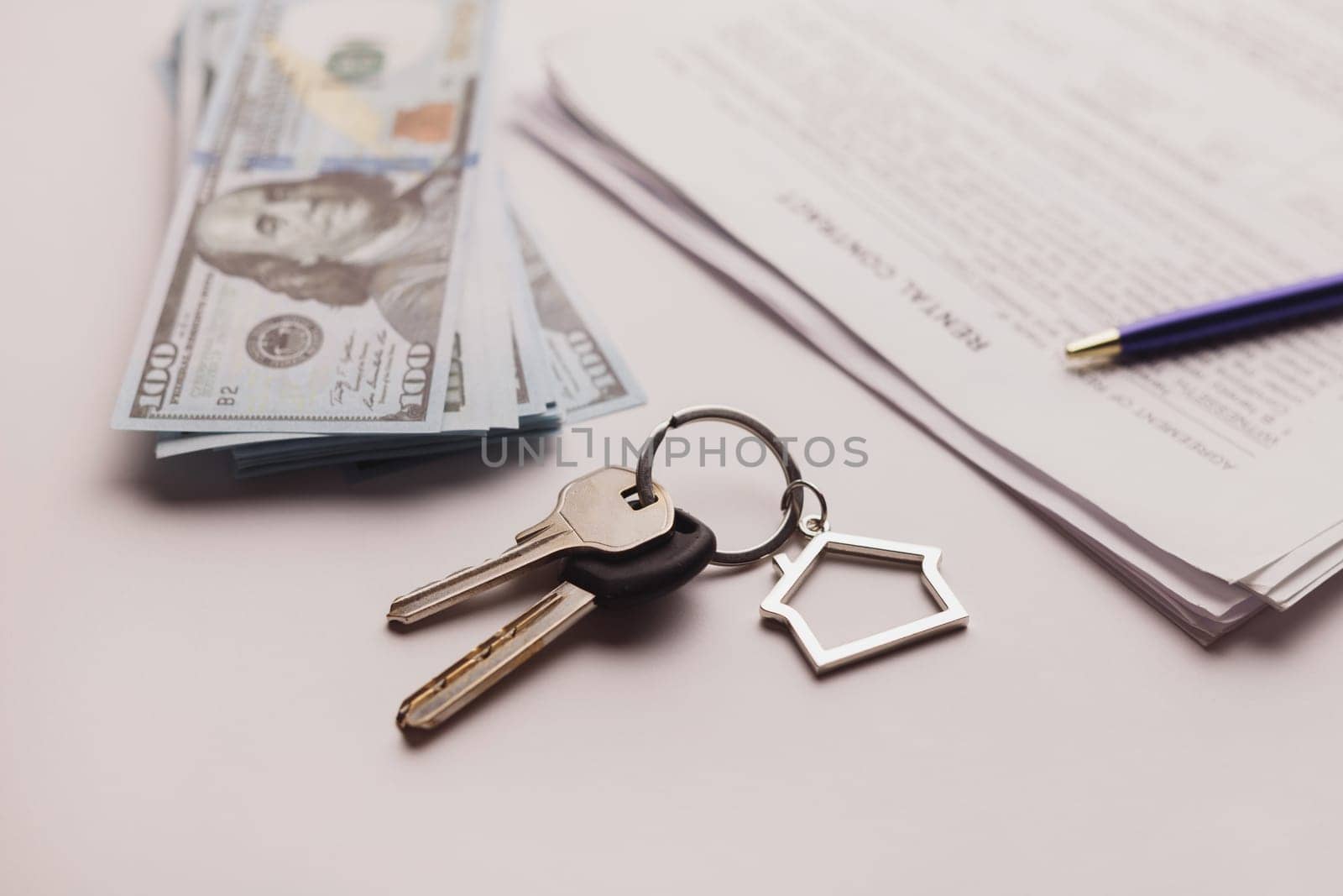 Real estate purchase contract with money and home keys on white table. Rental deal business trip living long term rental. Payment cash