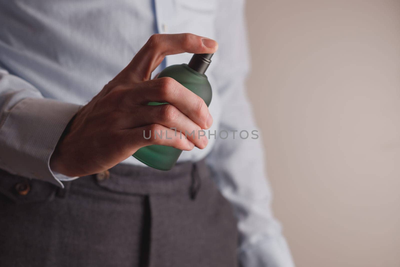 Man in formal wear holding perfume bottle, closeup. Space for text.