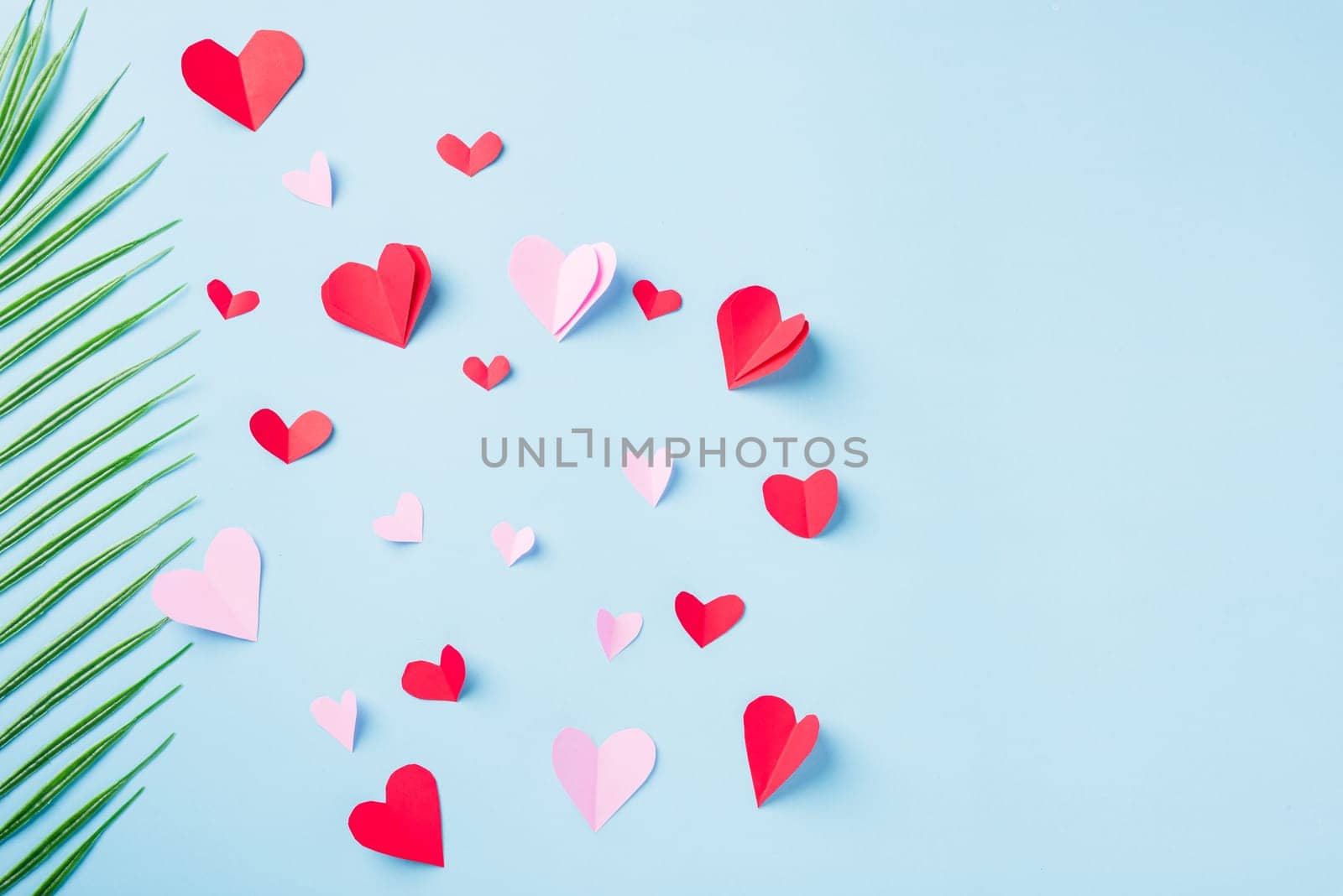 Valentines' day background. Pattern beautiful red paper hearts cut composition greeting card isolated on blue background with copy space, Symbol of love Top View from above