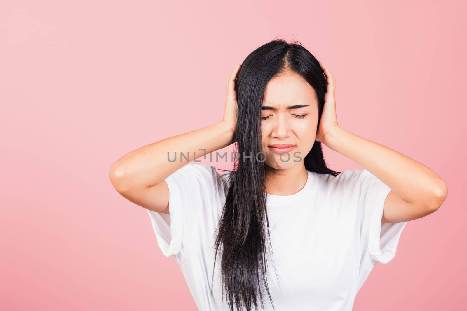 Asian portrait beautiful cute young woman have closed ears with hand palms and close eyes, studio shot isolated on pink background, Thai female covers ears for loud noise with copy space