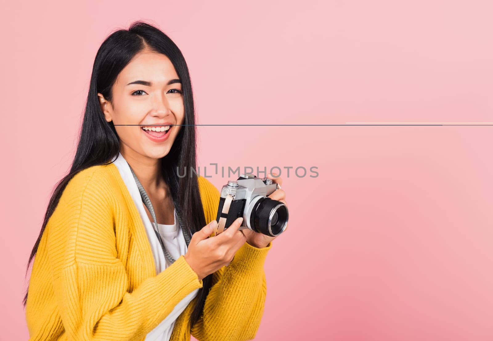 Attractive energetic happy Asian portrait beautiful cute young woman teen excited smiling holding vintage photo camera, studio shot isolated on pink background, traveler female photographer
