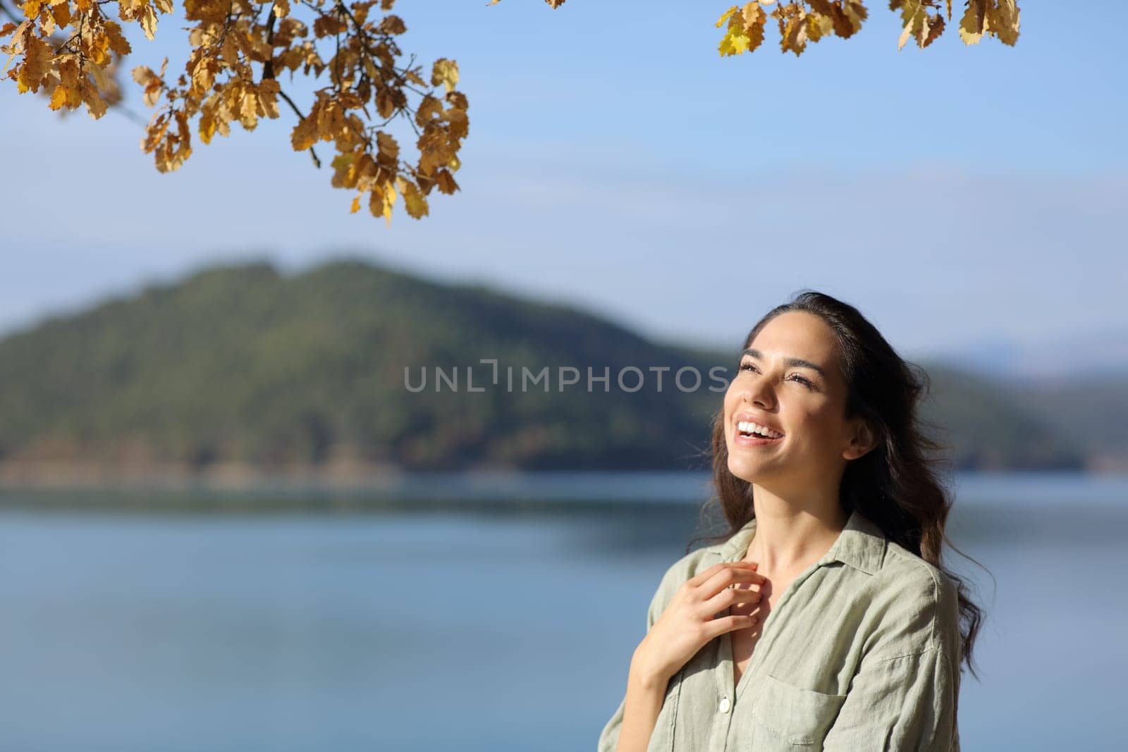 Amazed woman looking up in a lake on holiday