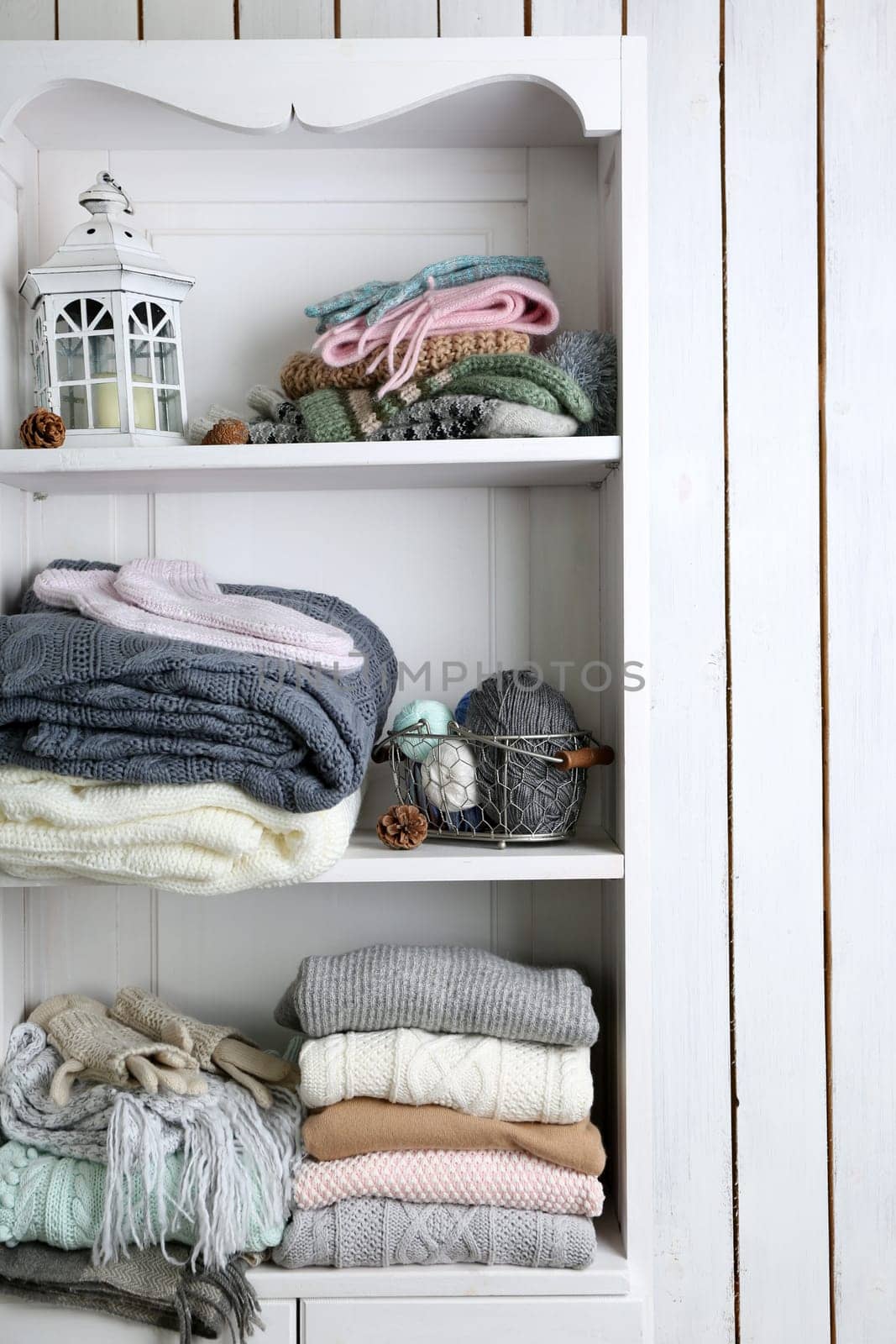 Knitting clothes and yarn on wooden background