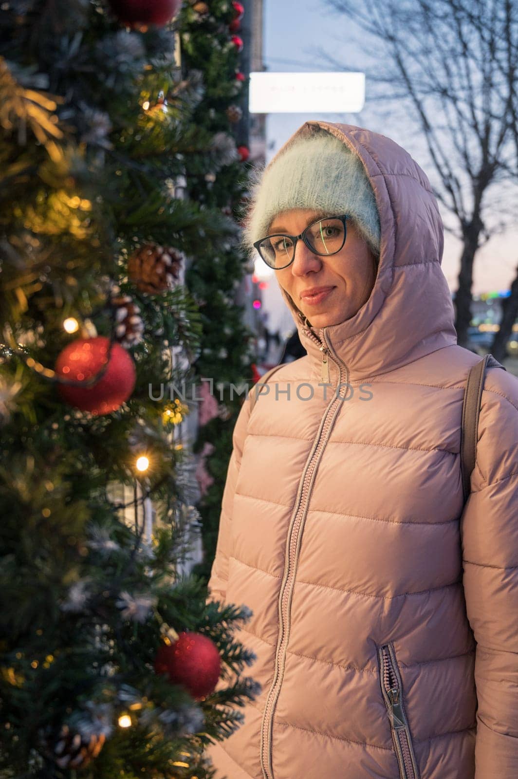 Pretty Woman near illuminated new year decorated window. Xmas holidays, or shopping on New Year or Christmas concept