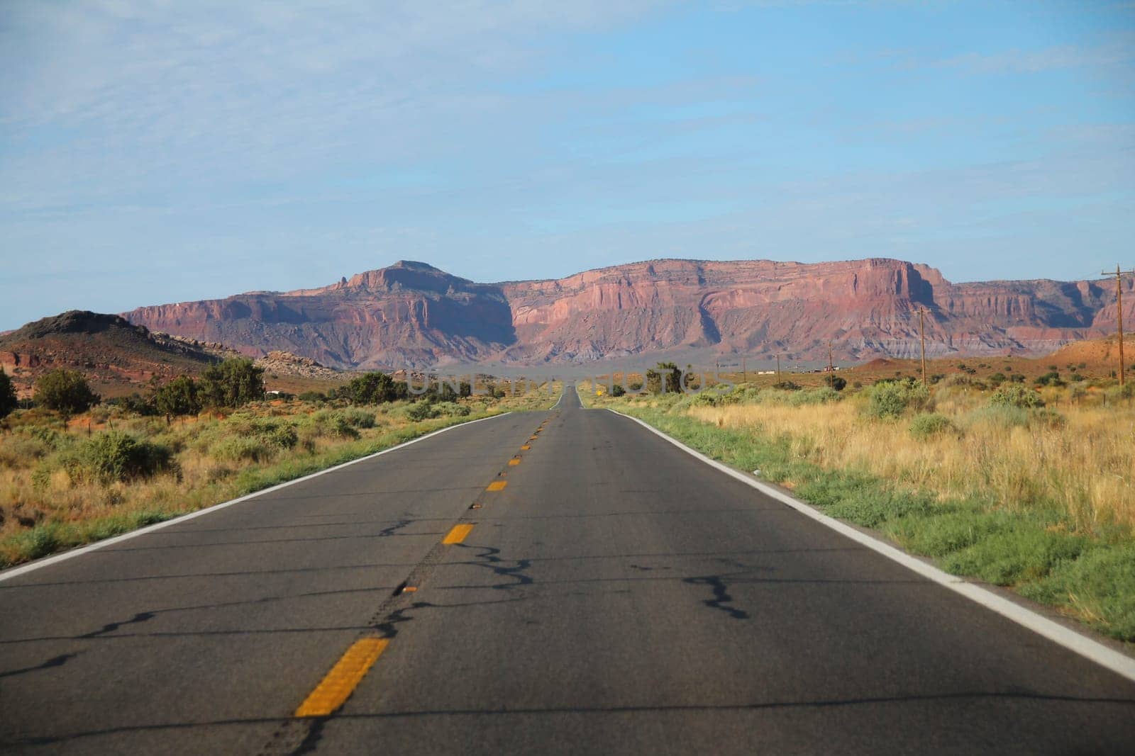 The long old country road to the monument mesa at the end in Arizona
