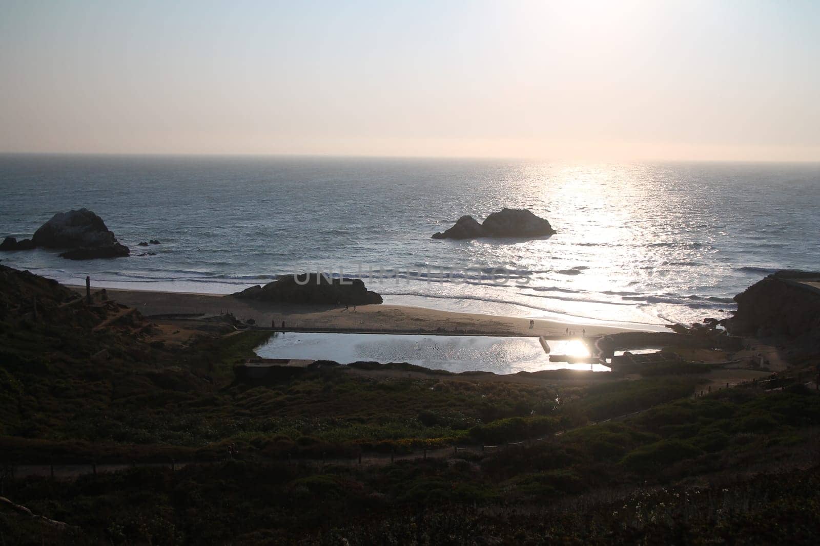 A yellow sunset over the ocean on Sutro Baths in San Francisco in California