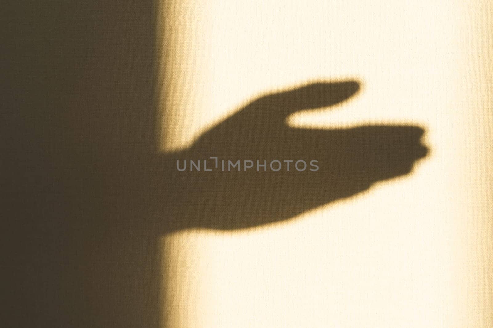 Shadow of hand showing gesture on the wall close up