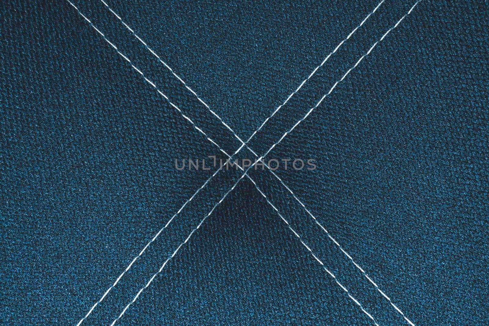 Dark blue denim background with white stitching close up background