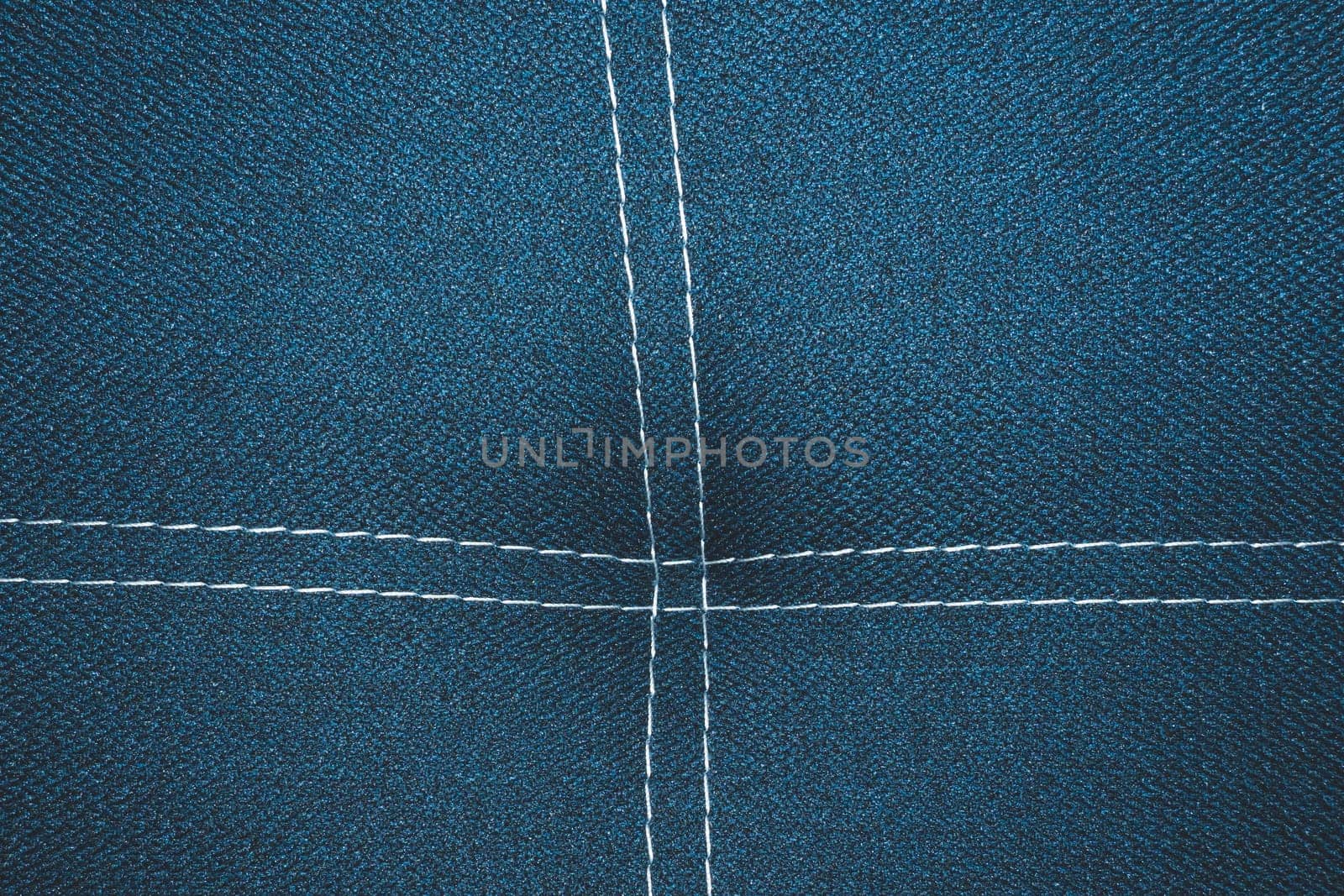 Dark blue denim background with white stitching close up background