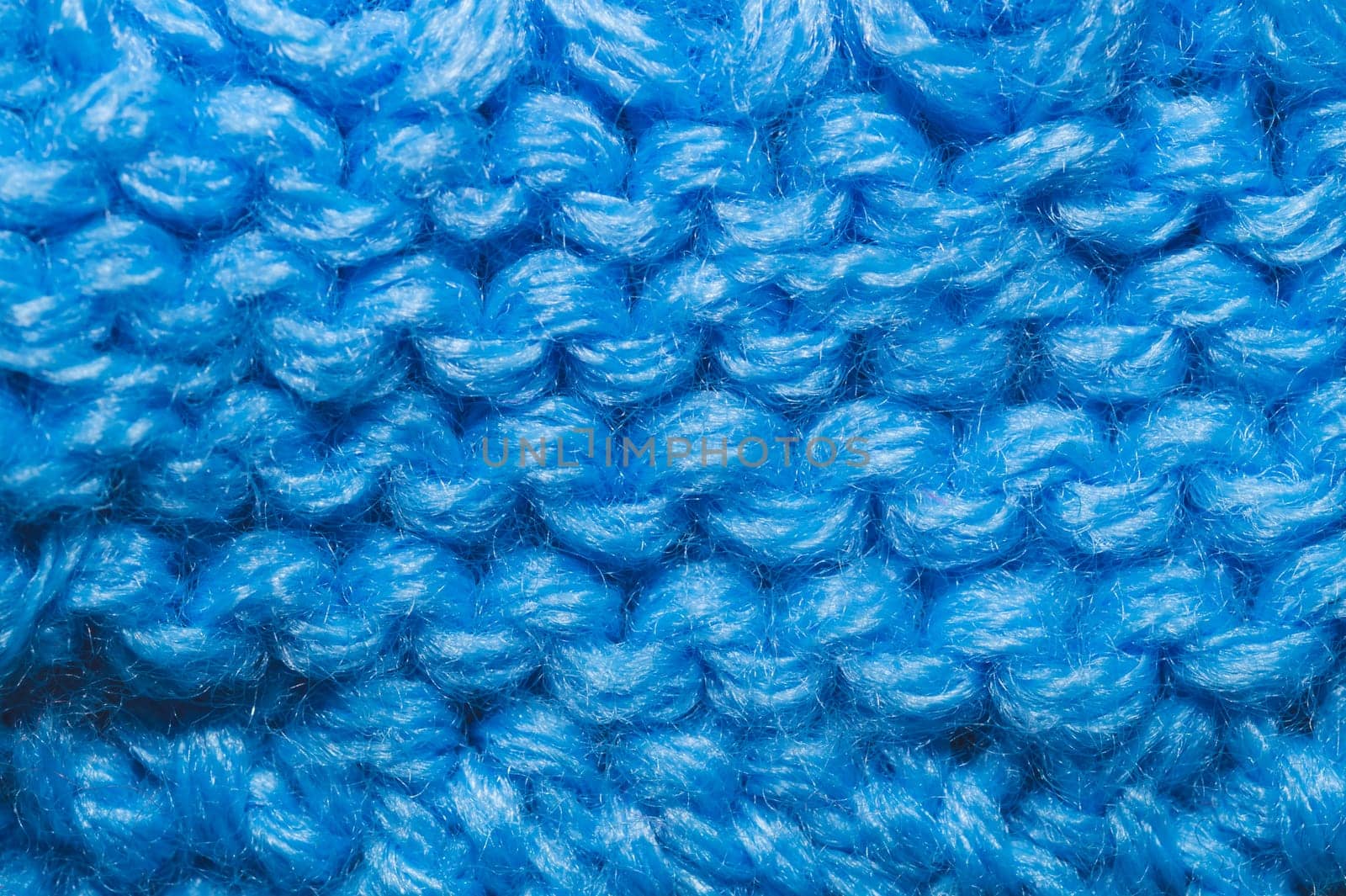 Knitted background close up. blue woolen fabric macro