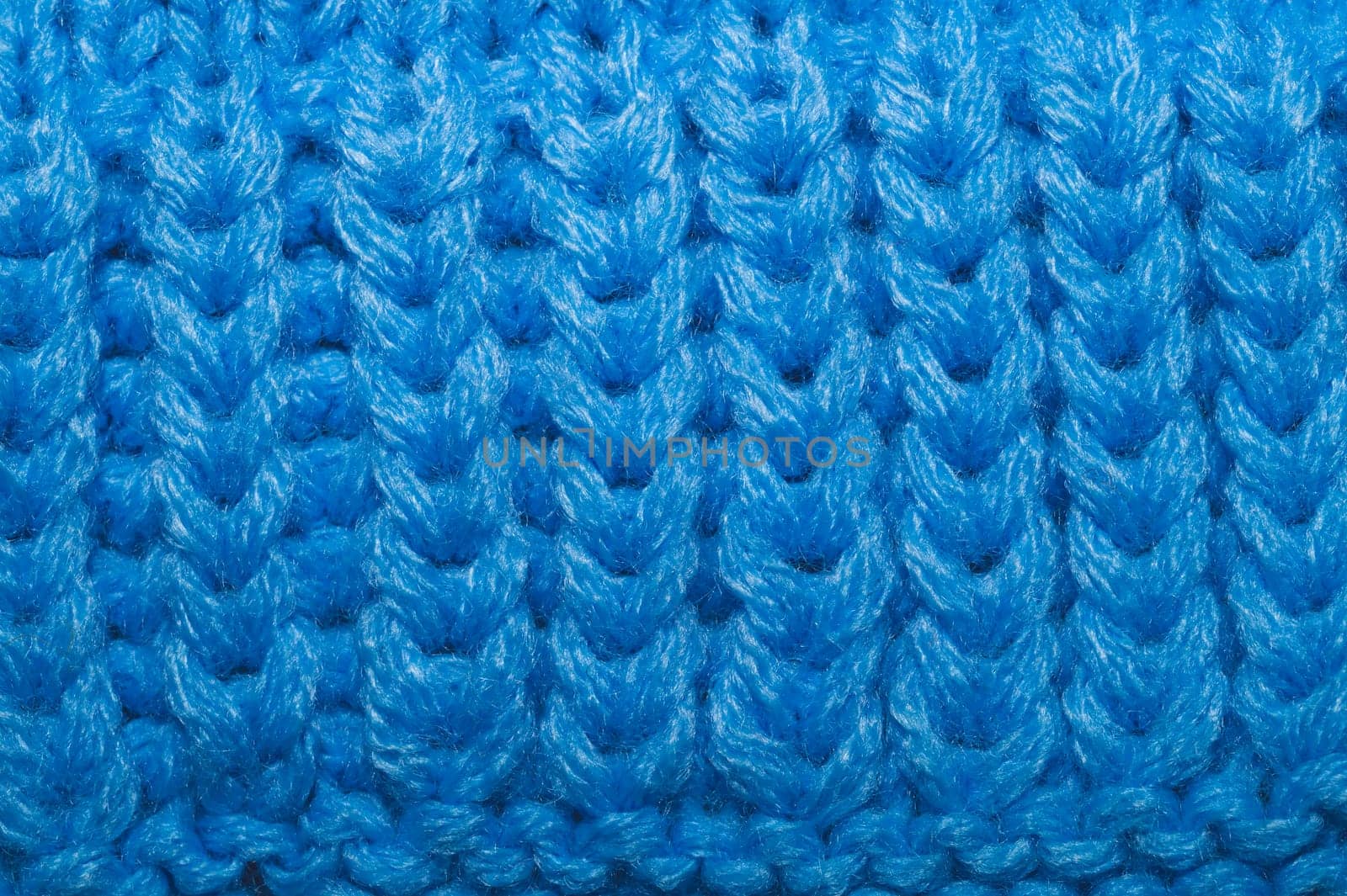 Knitted background close up. blue woolen fabric macro