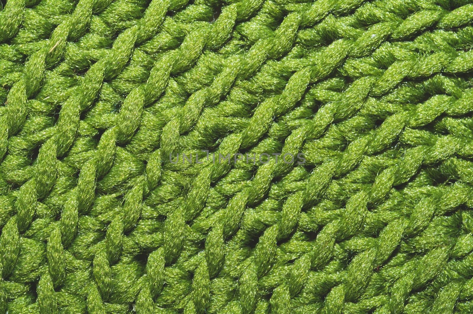 Knitted background close up. green woolen fabric macro