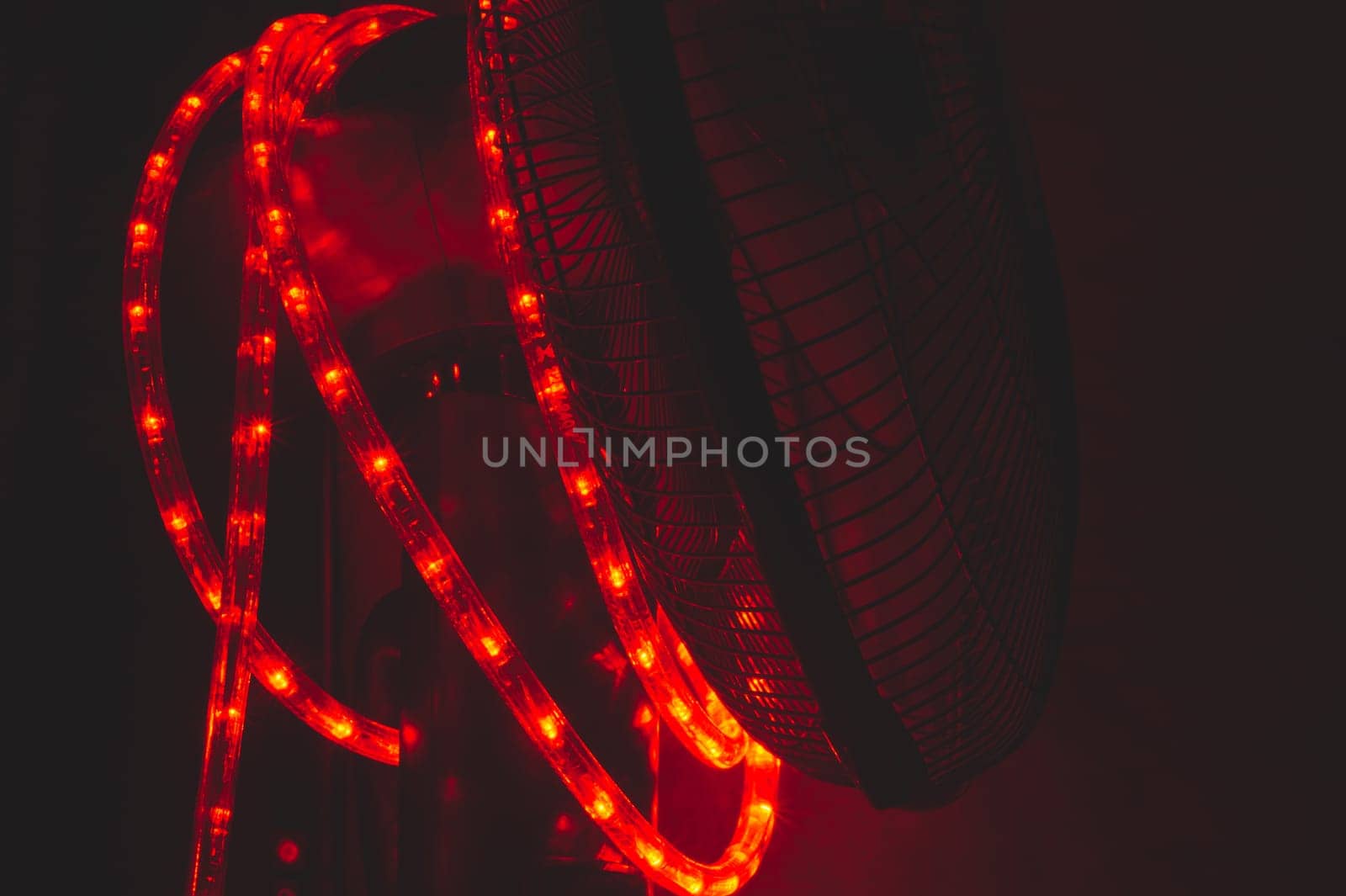 Garland of red light bulbs shines in the dark