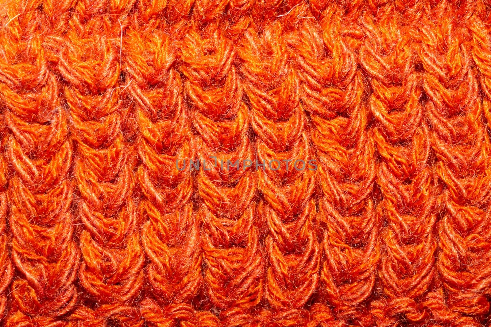 Knitted background close up. orange woolen fabric macro