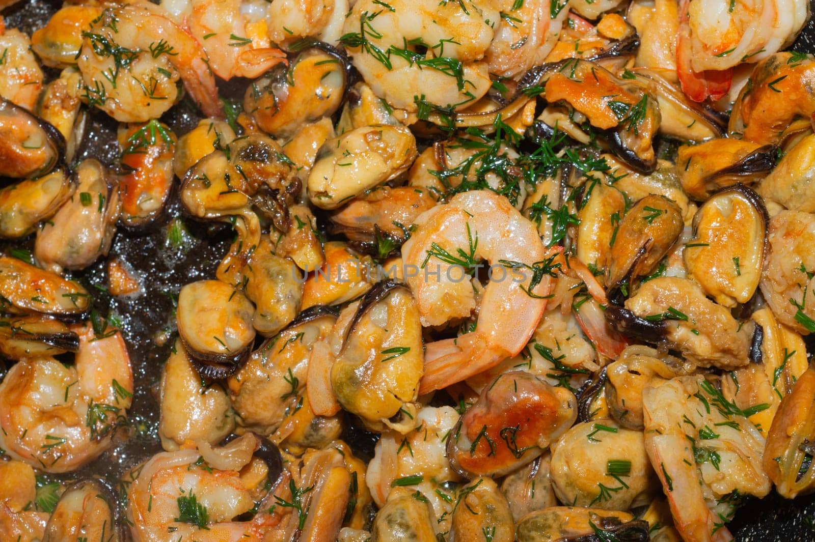 Fried prawns and mussels. grilled seafood close up. cooking process