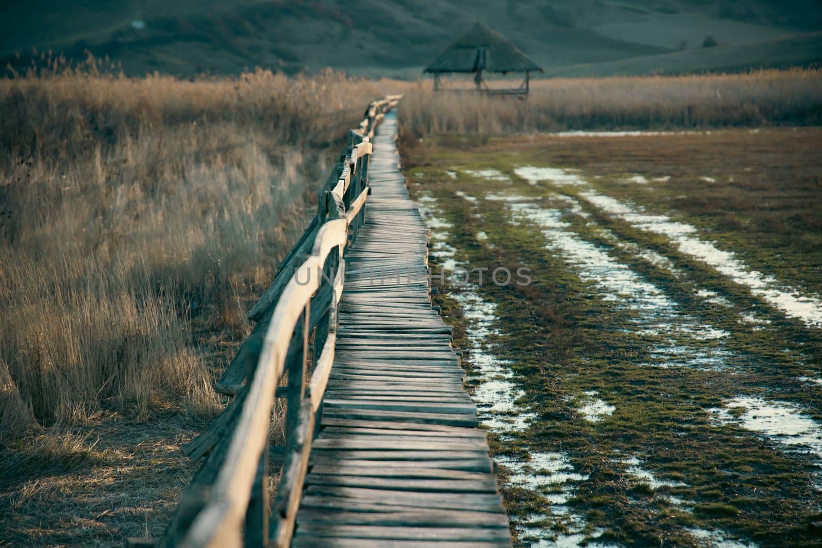 Old wooden boardwalk with a railing on the side and watchtower in the Sic reed reservation, Cluj , Romania