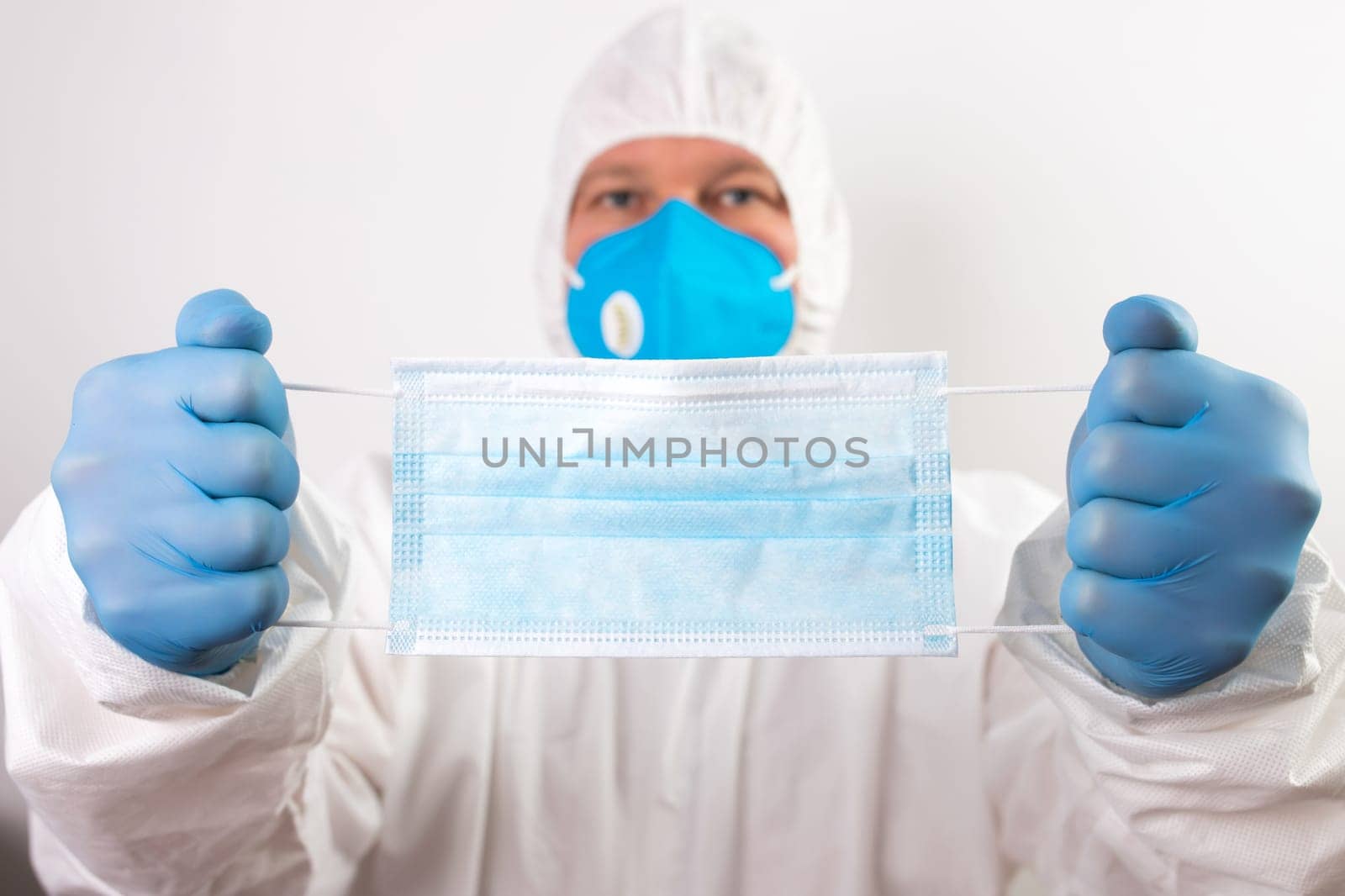 Doctor hand wear blue medical gloves holds antivirus face mask for pandemic diseases. Outbreak, Covid19 concept