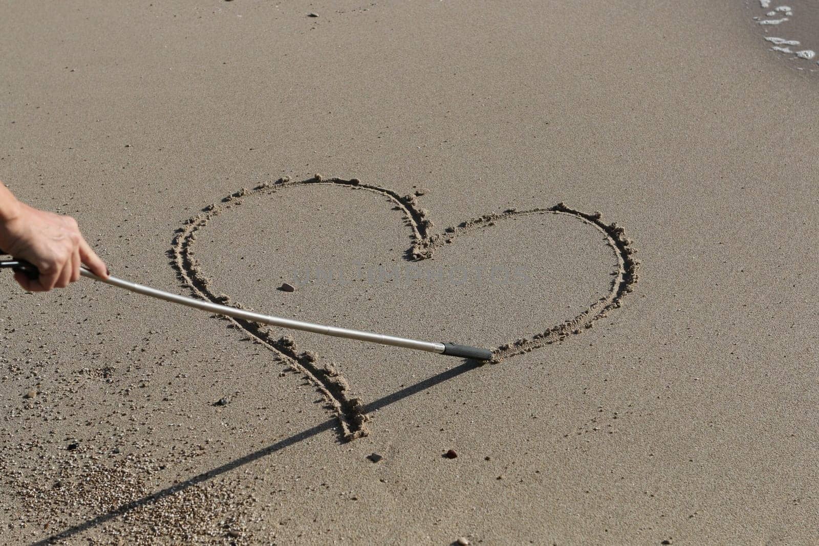Drawing a heart on a sandy beach
