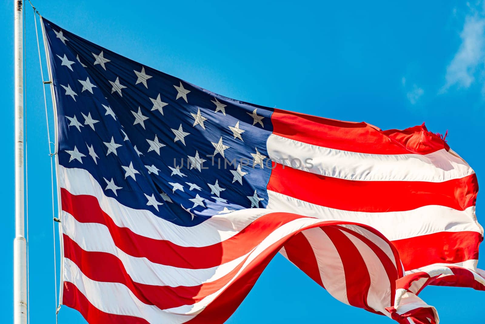 US american flag and blue cloudy sky with clouds in background