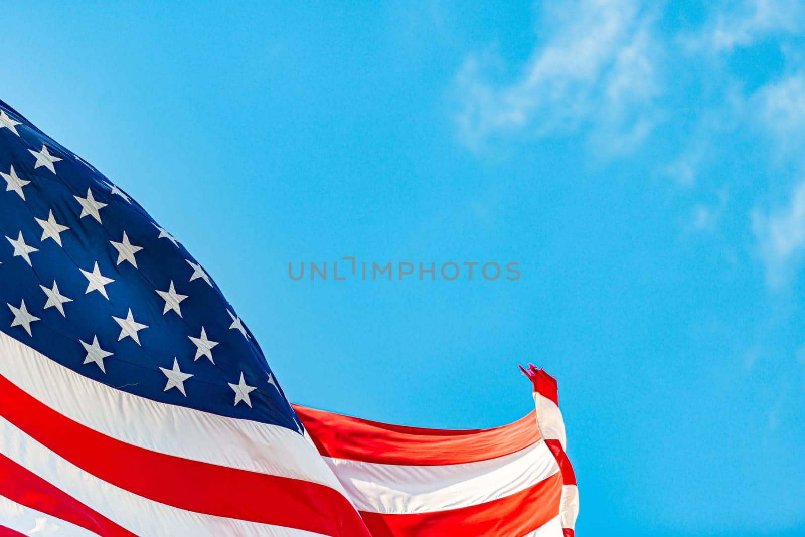 US american flag and blue cloudy sky with clouds in background