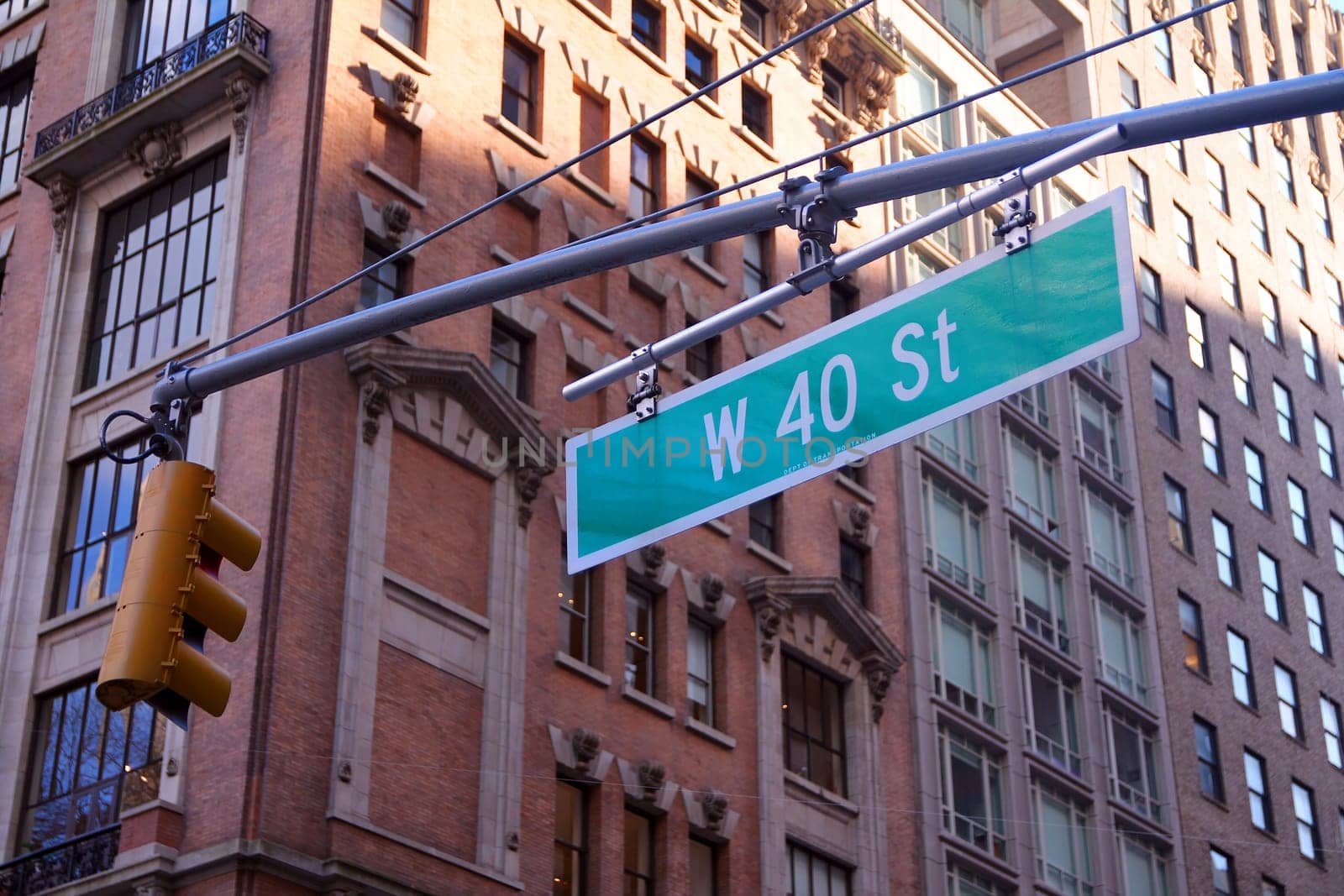 Green big West 40th Street sign hanging on a arch pole in the streets of midtown Manhattan in New York City