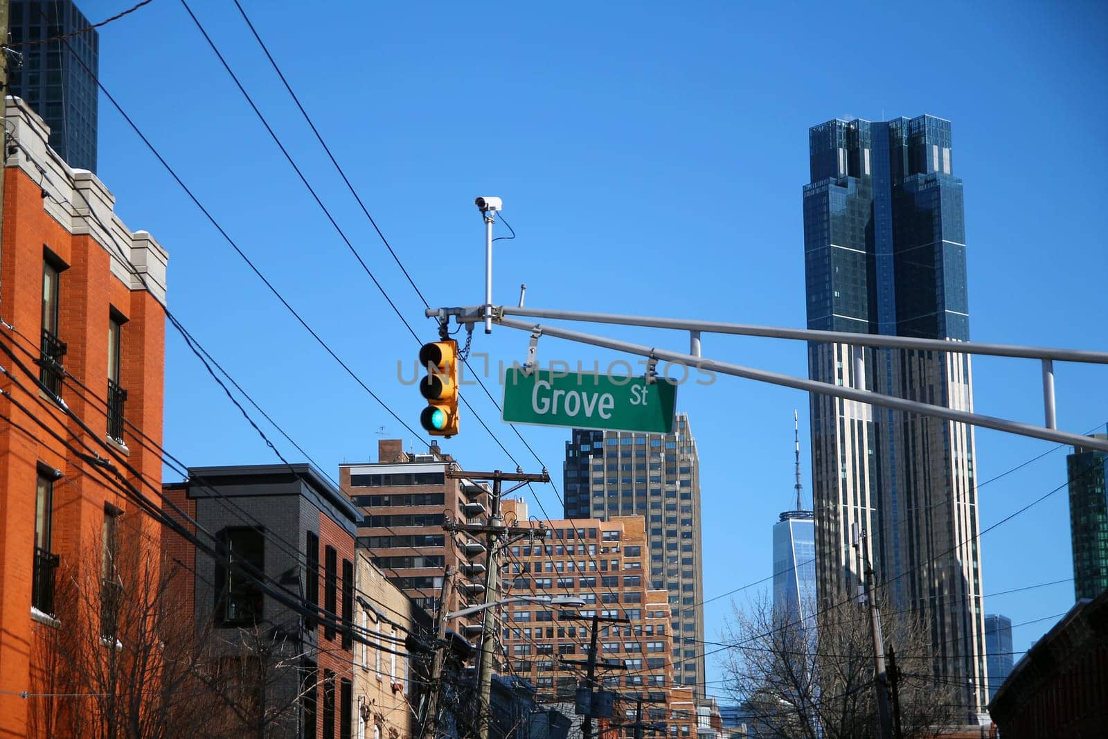 Green big Grove Street sign hanging on a arch pole between traffic lights in the streets of downtown Jersey City