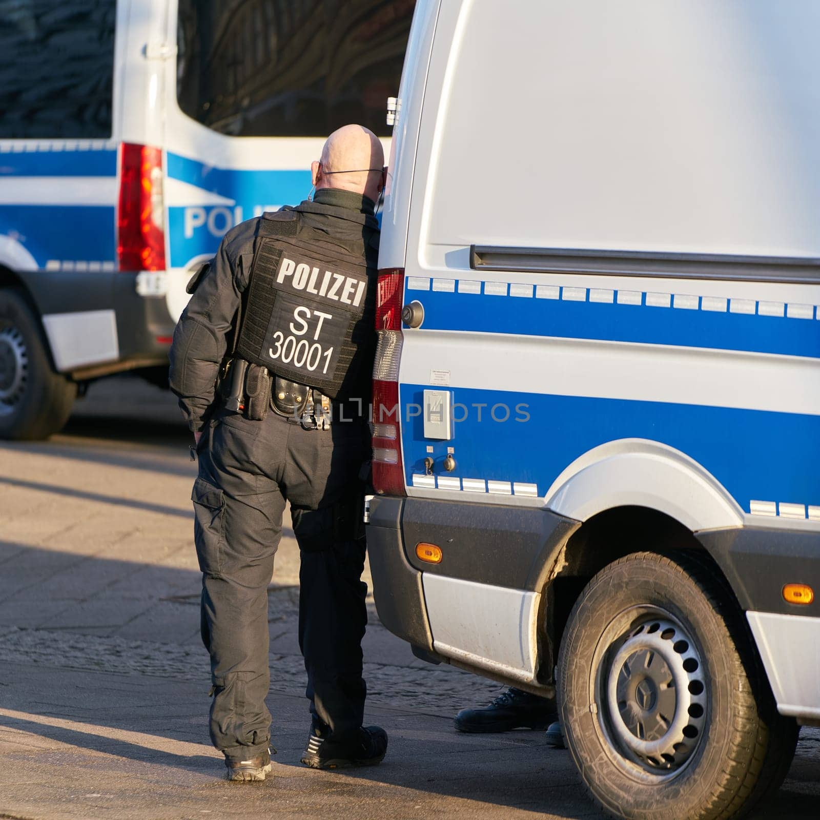 Police officer on the sidelines of a demonstration in Magdeburg takes a break and gets bored
