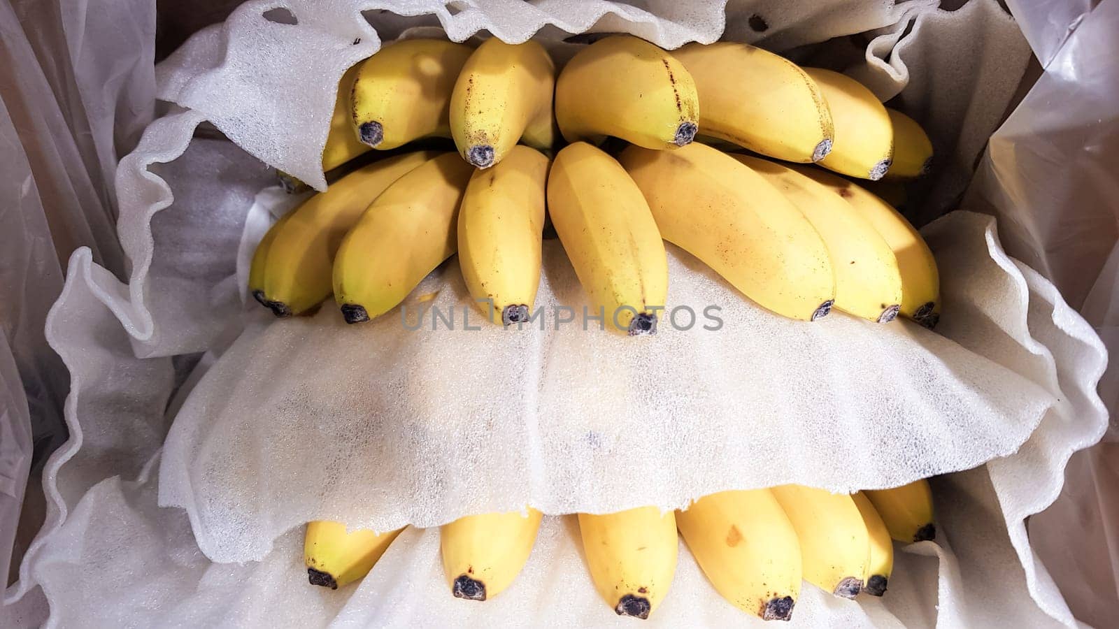 Ripe bananas in a box in a store. At the display window