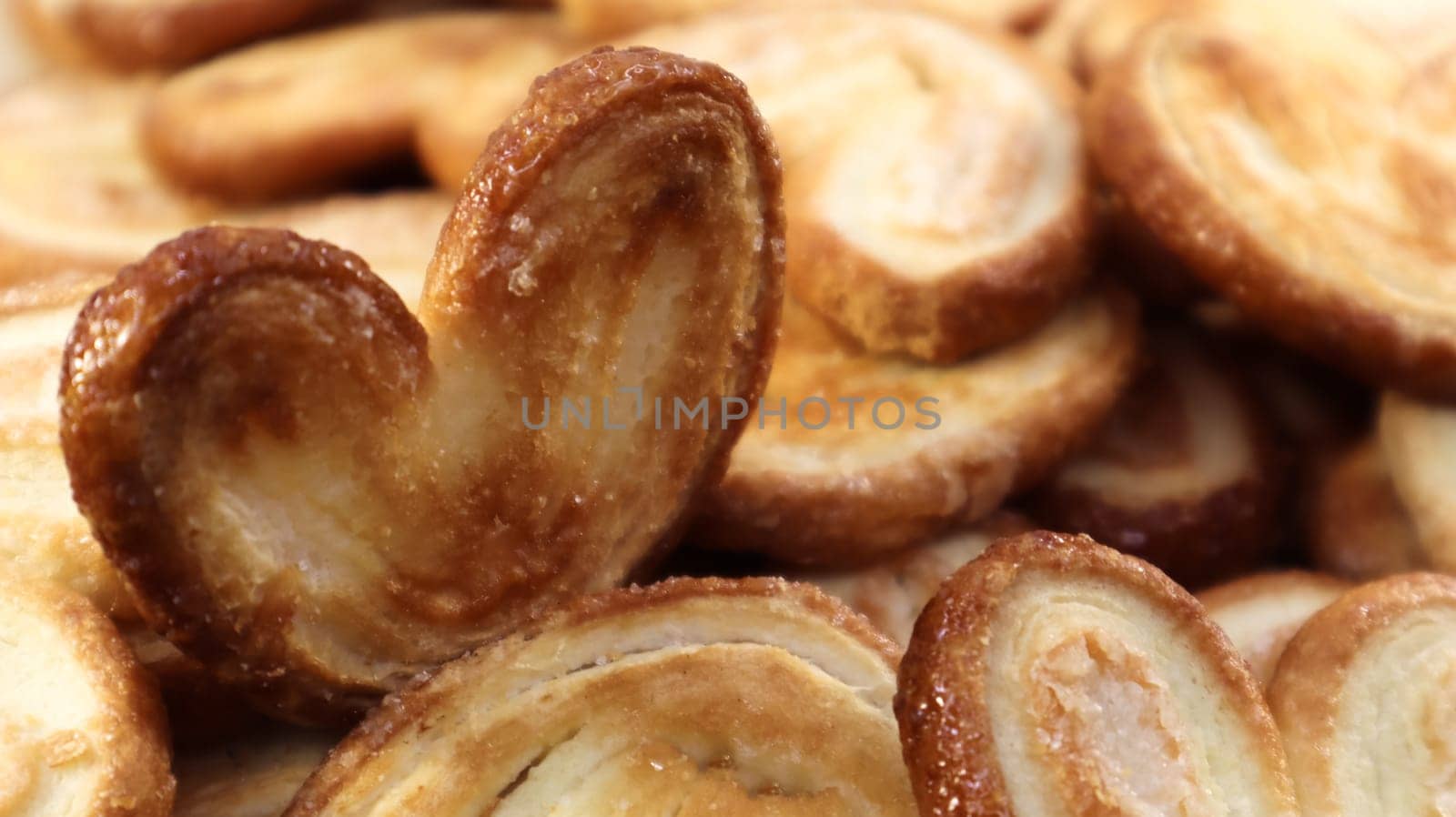 Fresh puff pastry palm cookies in the shape of a heart. Classic French pastries. Pig ear, elephant ear cookies, French hearts